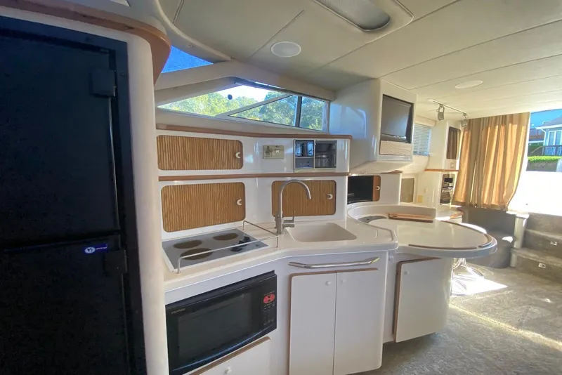 Slide: The Image of Interior of 1996 Sea Ray 440 Express Bridge yacht, featuring modern kitchen amenities. - 24