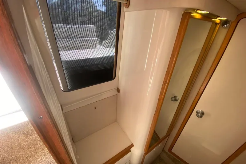 Slide: The Image of Interior of 1996 Sea Ray 440 Express Bridge, featuring a compact cabin space. - 34