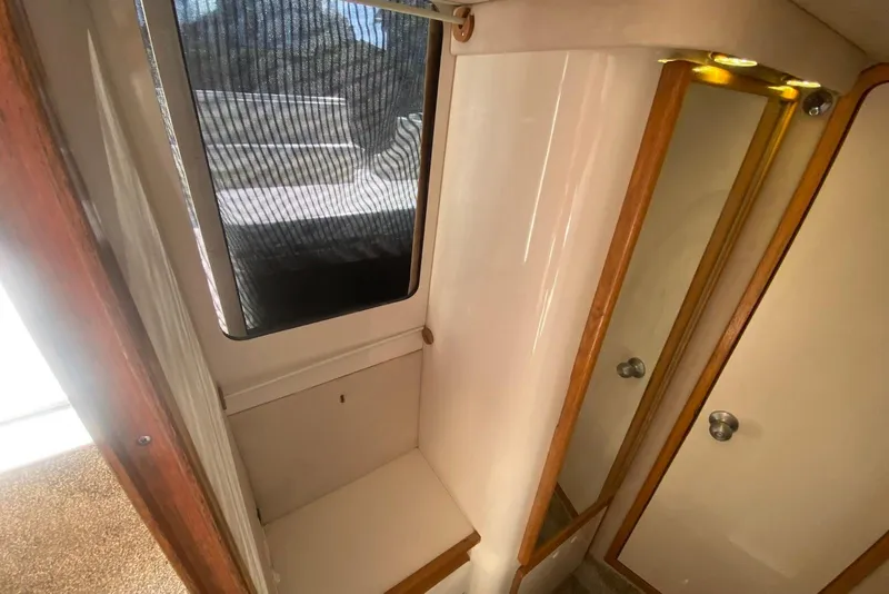 Slide: The Image of Interior of 1996 Sea Ray 440 Express Bridge, featuring a compact cabin space. - 35