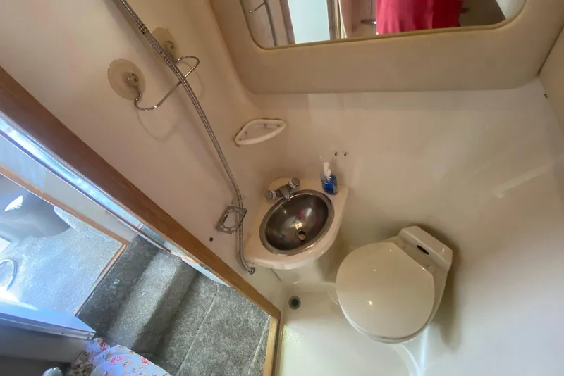 Slide: The Image of Bathroom interior of 1996 Sea Ray 440 Express Bridge yacht, featuring sink and toilet. - 37
