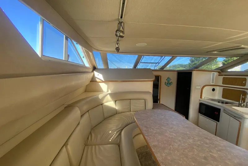 Slide: The Image of Interior of 1996 Sea Ray 440 Express Bridge with leather seating and kitchenette. - 42
