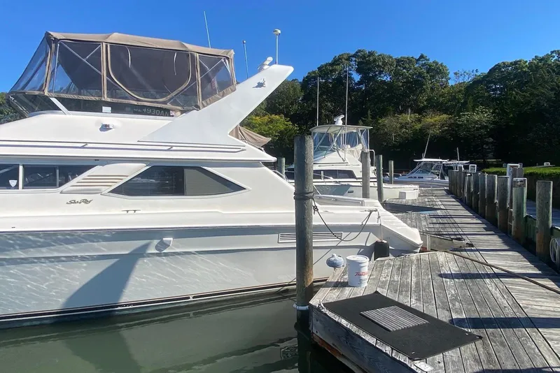 Slide: The Image of 1996 Sea Ray 440 Express Bridge docked at a marina on a sunny day. - 5