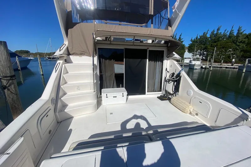 Slide: The Image of 1996 Sea Ray 440 Express Bridge yacht deck with stairs and marina view. - 6