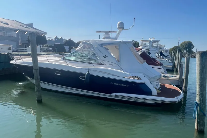 Slide: The Image of 2010 Monterey 400 Sport Yacht docked in a marina under clear blue skies. - 2