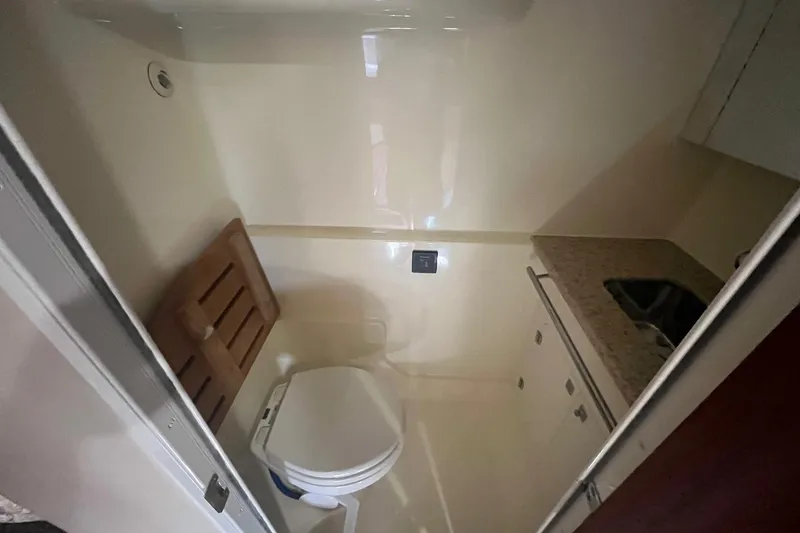 Slide: The Image of 2010 Monterey 400 Sport Yacht bathroom with toilet, sink, and wooden seat. - 34