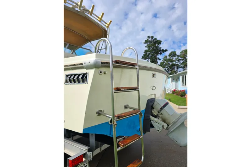 Slide: The Image of 1989 Hinterhoeller Limestone boat with ladder and outboard motor, parked outdoors. - 10