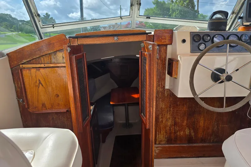 Slide: The Image of 1989 Hinterhoeller Limestone boat interior with wooden cabin doors and steering wheel. - 12