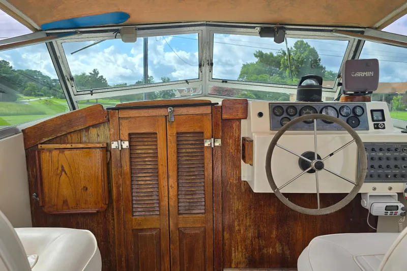 Slide: The Image of 1989 Hinterhoeller Limestone boat interior with wooden paneling and steering wheel. - 16
