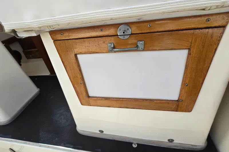 Slide: The Image of 1989 Hinterhoeller Limestone boat interior with wooden storage compartment and handle. - 20