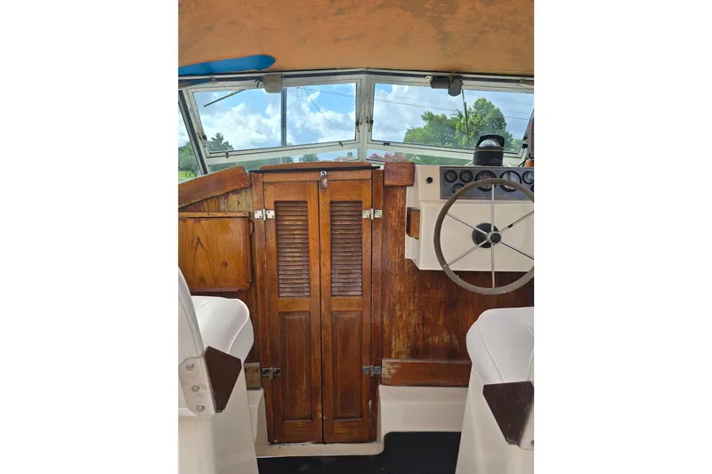 Slide: The Image of 1989 Hinterhoeller Limestone boat interior with wooden cabinetry and steering wheel. - 29