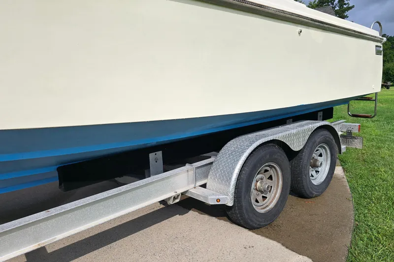 Slide: The Image of 1989 Hinterhoeller Limestone boat on a dual-axle trailer, parked on concrete. - 3