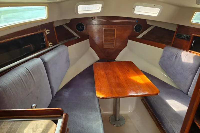 Slide: The Image of 1989 Hinterhoeller Limestone boat interior with wooden table and cushioned seating. - 30