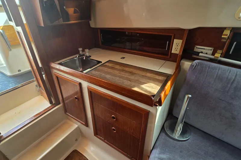 Slide: The Image of 1989 Hinterhoeller Limestone boat interior with wooden cabinetry and compact kitchen area. - 31