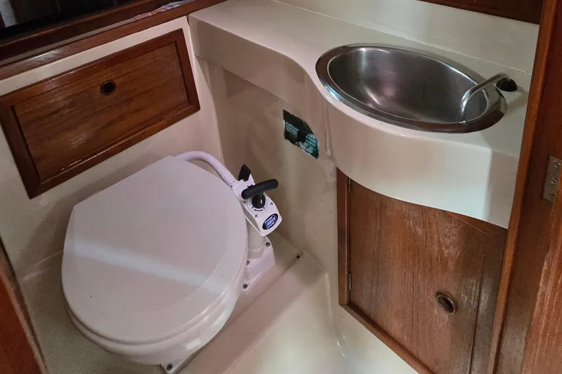 Slide: The Image of 1989 Hinterhoeller Limestone boat bathroom with toilet and stainless steel sink. - 34