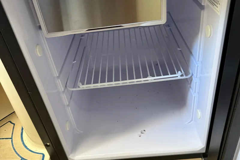 Slide: The Image of Empty refrigerator inside a 1996 Grady-White Marlin 300 boat. - 24