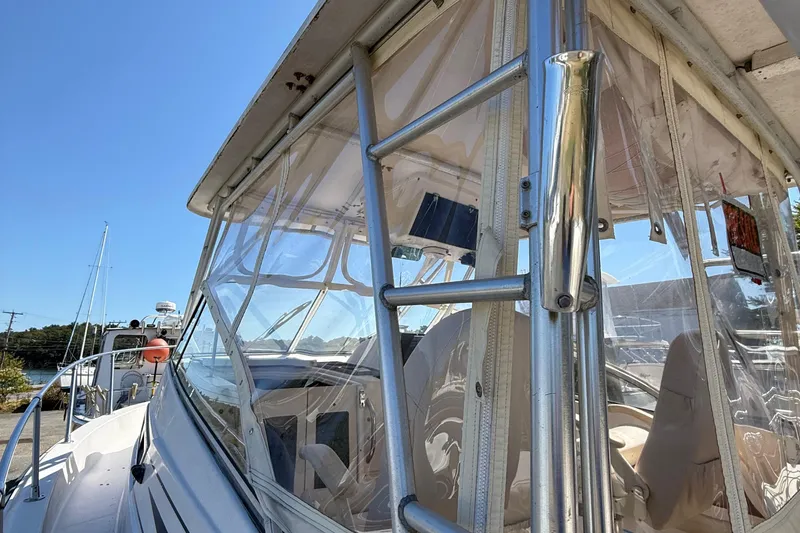 Slide: The Image of 1996 Grady-White Marlin 300 boat with clear enclosure and metal framework under blue sky. - 37