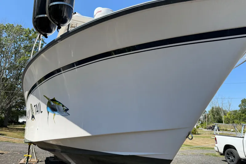 Slide: The Image of 1996 Grady-White Marlin 300 boat with fish graphic, parked outdoors. - 4