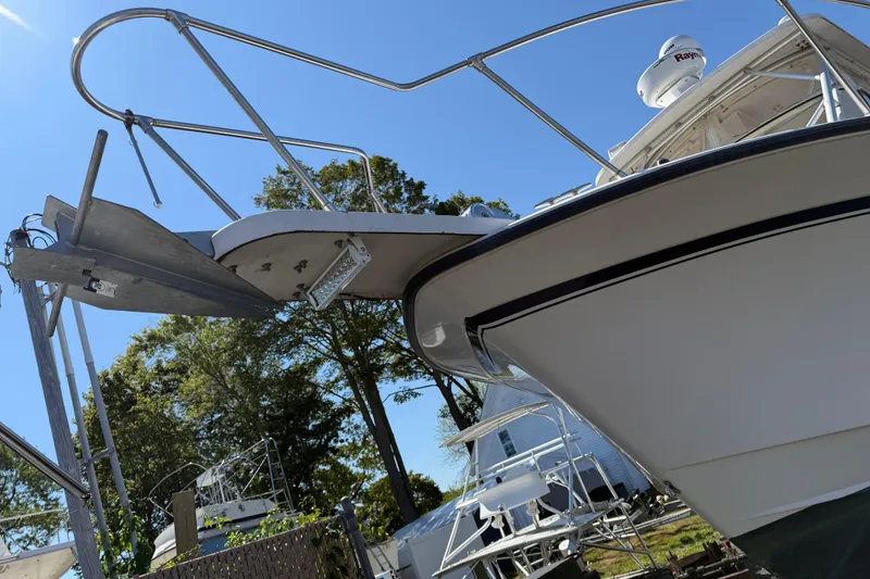 Slide: The Image of 1996 Grady-White Marlin 300 boat with radar, docked under clear blue sky. - 5