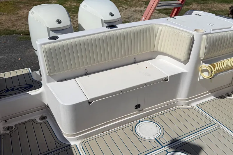 Slide: The Image of 1996 Grady-White Marlin 300 boat interior with cushioned seating and twin outboard motors. - 7