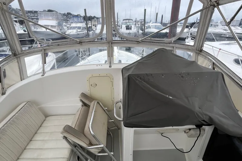 Slide: The Image of 1989 Albin 32 Sportfisher cockpit with covered controls, marina view in background. - 20
