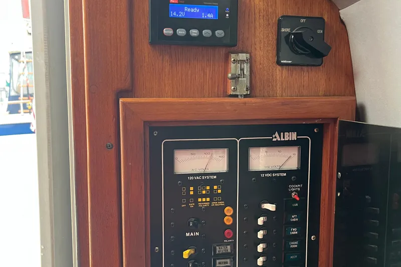 Slide: The Image of Control panel of a 1989 Albin 32 Sportfisher boat, featuring voltage meters and switches. - 24