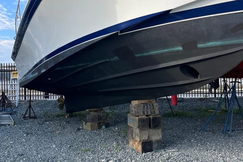 Slide: The Image of 1989 Albin 32 Sportfisher boat on blocks, hull view, outdoor storage. - 7