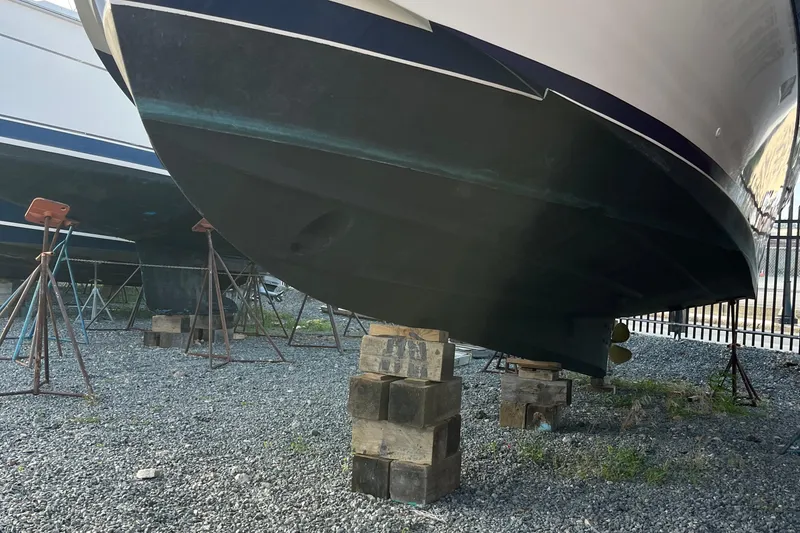 Slide: The Image of 1989 Albin 32 Sportfisher boat on blocks, under maintenance in a gravel yard. - 8