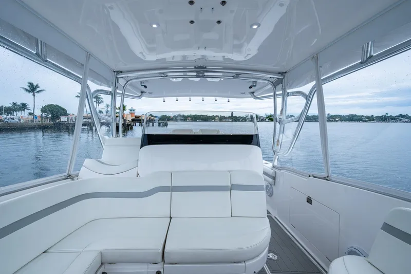 Slide: The Image of Interior view of 2019 Intrepid 407 Cuddy boat with white seating and waterfront backdrop. - 29