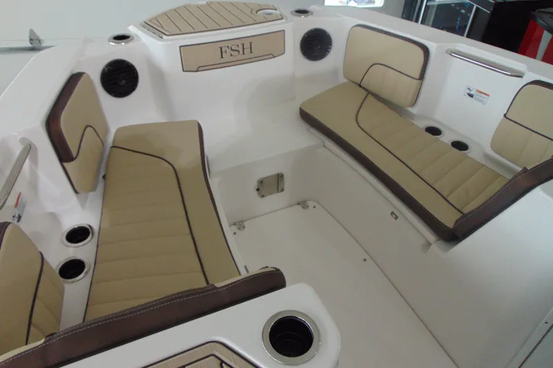 Slide: The Image of Interior of 2026 Yamaha Boats 222 FSH Sport E, featuring tan cushioned seating. - 13