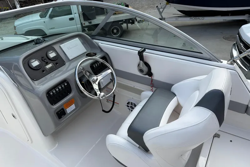 Slide: The Image of 2021 Robalo R227 Dual Console boat interior with steering wheel and dashboard controls. - 12