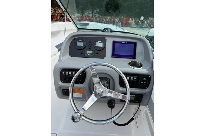 Slide: The Image of 2021 Robalo R227 Dual Console boat dashboard with steering wheel and navigation controls. - 15