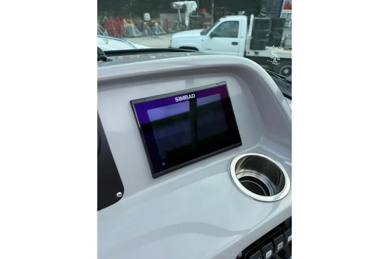 Slide: The Image of 2021 Robalo R227 Dual Console dashboard with Simrad display and cup holder. - 16