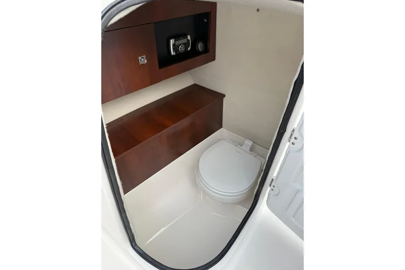 Slide: The Image of 2021 Robalo R227 Dual Console boat interior with compact marine toilet. - 18