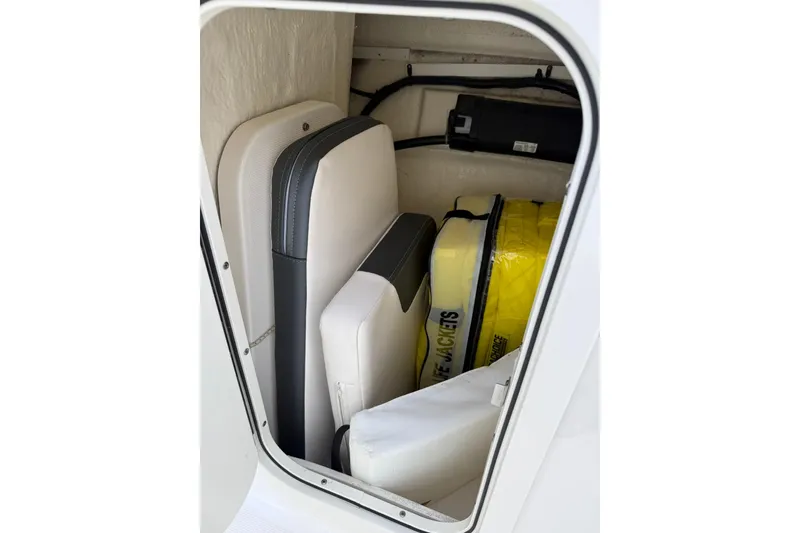 Slide: The Image of Storage compartment in 2021 Robalo R227 Dual Console with cushions and life jackets. - 19