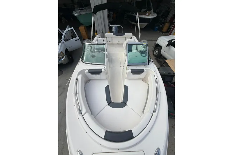 Slide: The Image of 2021 Robalo R227 Dual Console boat with spacious seating and sleek design in a garage. - 21