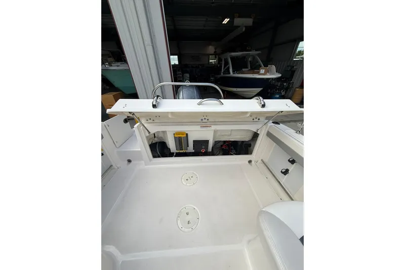 Slide: The Image of 2021 Robalo R227 Dual Console boat interior in a garage setting. - 9