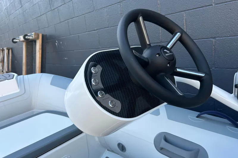 Slide: The Image of 2024 Highfield Classic 310 FCT boat steering wheel and control panel close-up. - 5