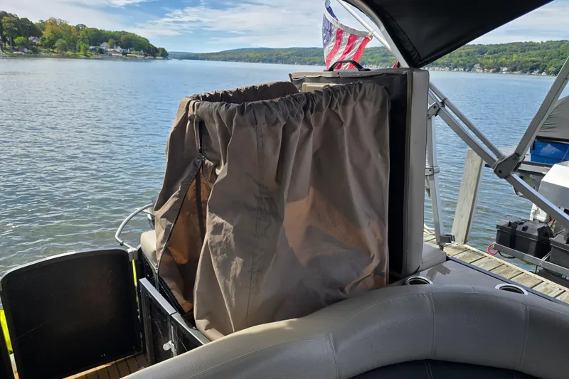 Slide: The Image of 2013 Premier 275 Boundary Waters pontoon boat on a scenic lake with American flag. - 11