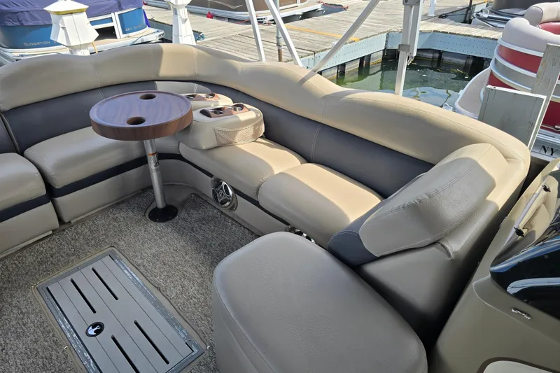 Slide: The Image of 2013 Premier 275 Boundary Waters pontoon boat interior with seating and table at dock. - 6