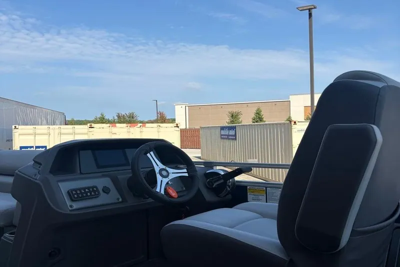 Slide: The Image of 2026 Sun Tracker SportFish 22 DLX boat interior with steering wheel and control panel. - 5