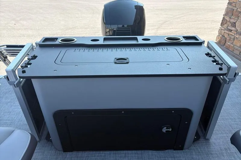 Slide: The Image of 2026 Sun Tracker SportFish 22 DLX boat console with cup holders and storage compartment. - 6