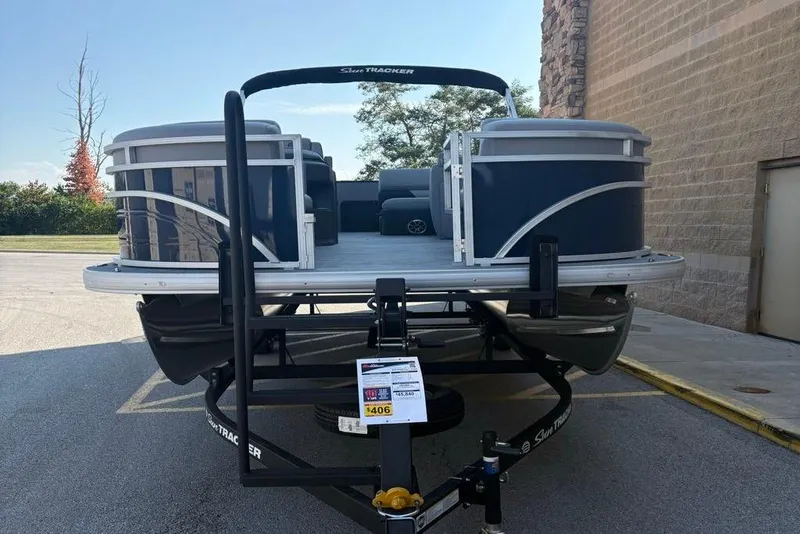 Slide: The Image of 2026 Sun Tracker SportFish 22 DLX pontoon boat on trailer in parking lot. - 75