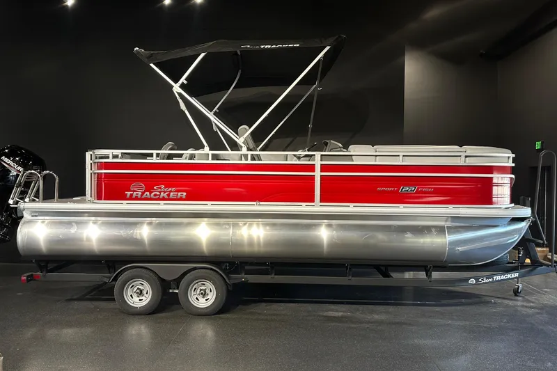 The Image of 2026 Sun Tracker SportFish 22 DLX pontoon boat with red exterior on display. - 0