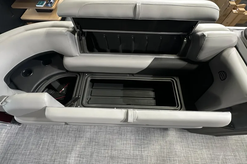 Slide: The Image of 2026 Sun Tracker SportFish 22 DLX boat interior storage compartment with cushioned seating. - 15