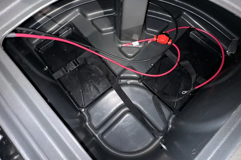 Slide: The Image of Battery compartment of 2026 Sun Tracker SportFish 22 DLX with red wiring and straps. - 16