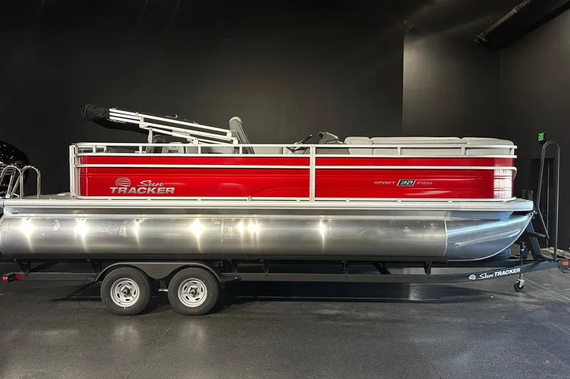 Slide: The Image of 2026 Sun Tracker SportFish 22 DLX pontoon boat with red exterior on trailer. - 2