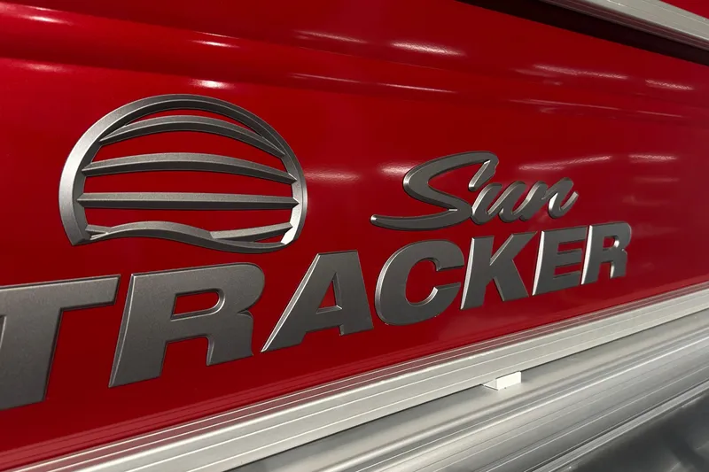 Slide: The Image of Close-up of 2026 Sun Tracker SportFish 22 DLX logo on red background. - 3