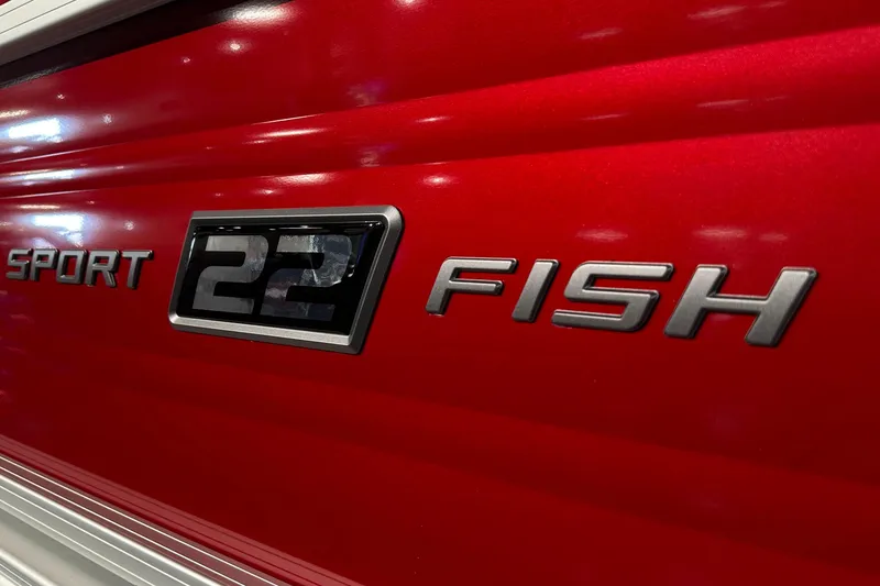 Slide: The Image of 2026 Sun Tracker SportFish 22 DLX logo on red boat exterior. - 4