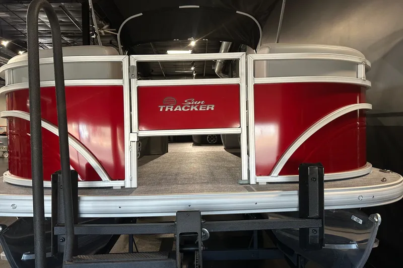 Slide: The Image of 2026 Sun Tracker SportFish 22 DLX pontoon boat with red exterior in showroom. - 5