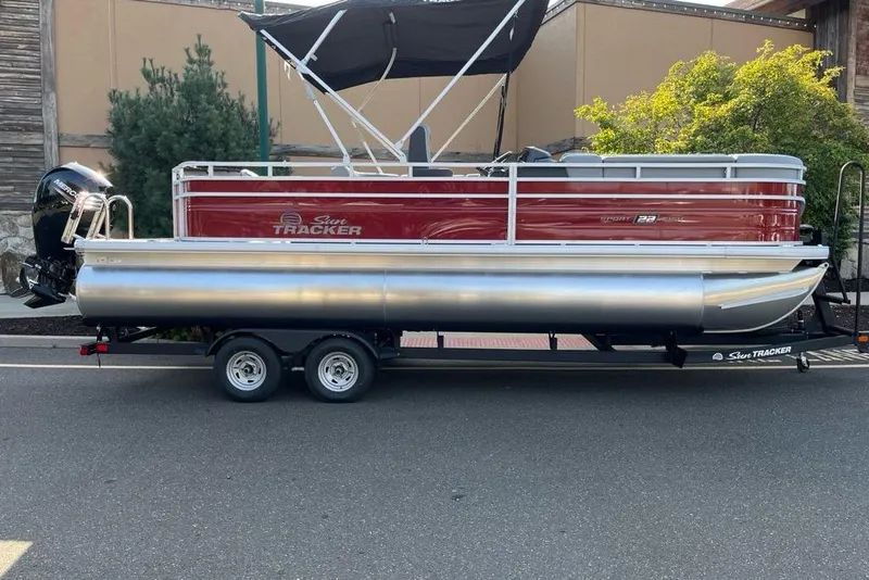 The Image of 2026 Sun Tracker SportFish 22 DLX pontoon boat on trailer, side view. - 0